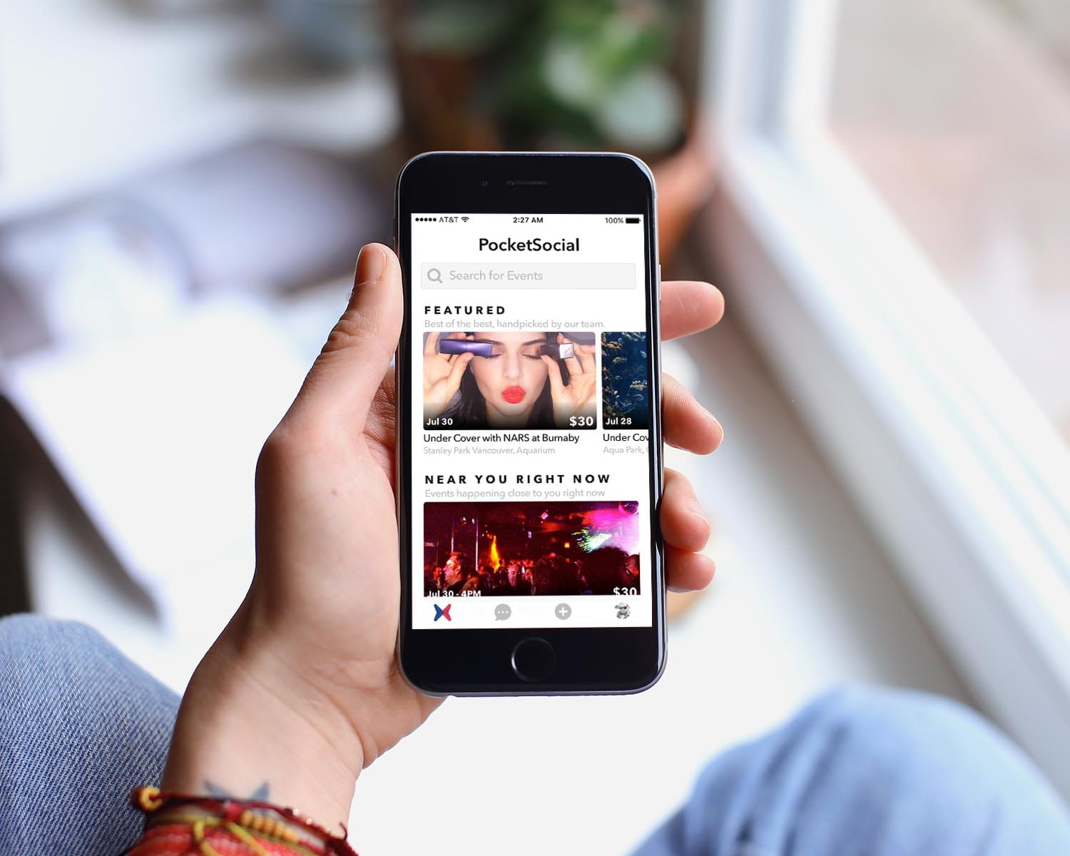 picture of a person holding an iphone with the screen showing the pocket social app